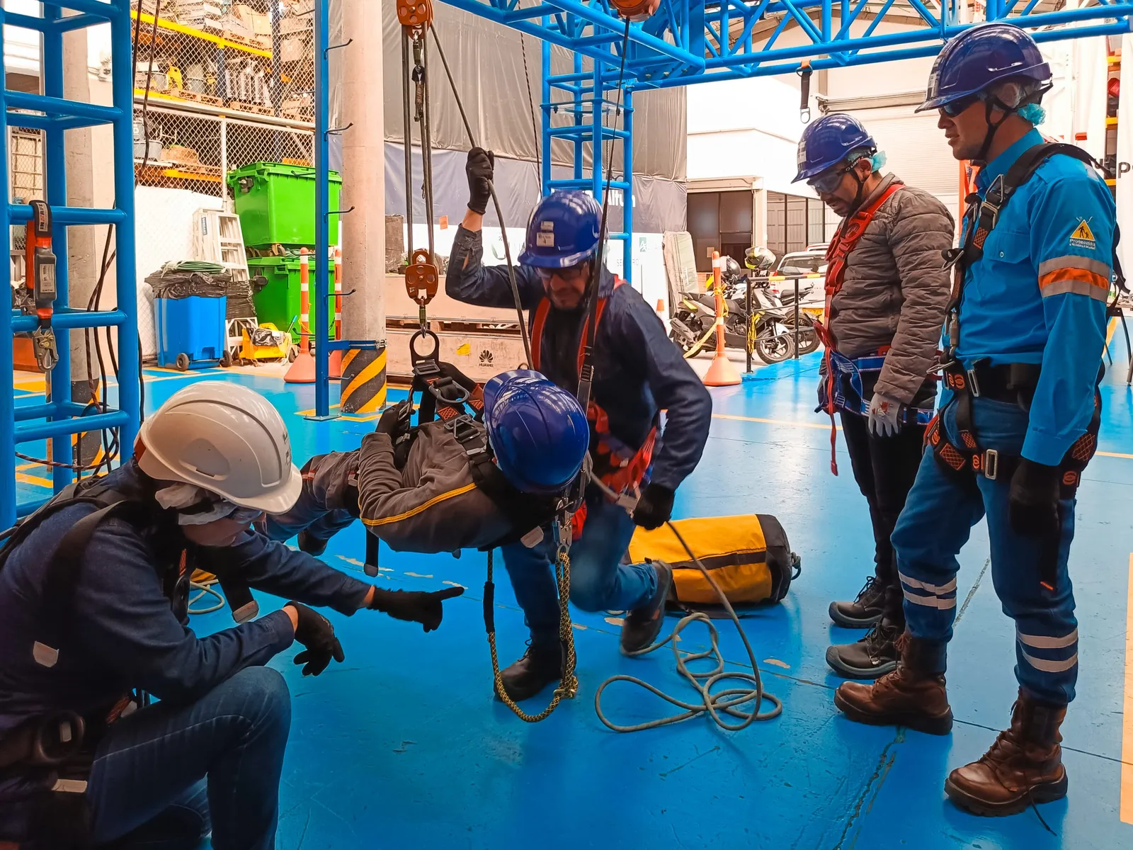 Equipo técnico de HSG Ingeniería con arnés preparando una maniobra en una planta industrial